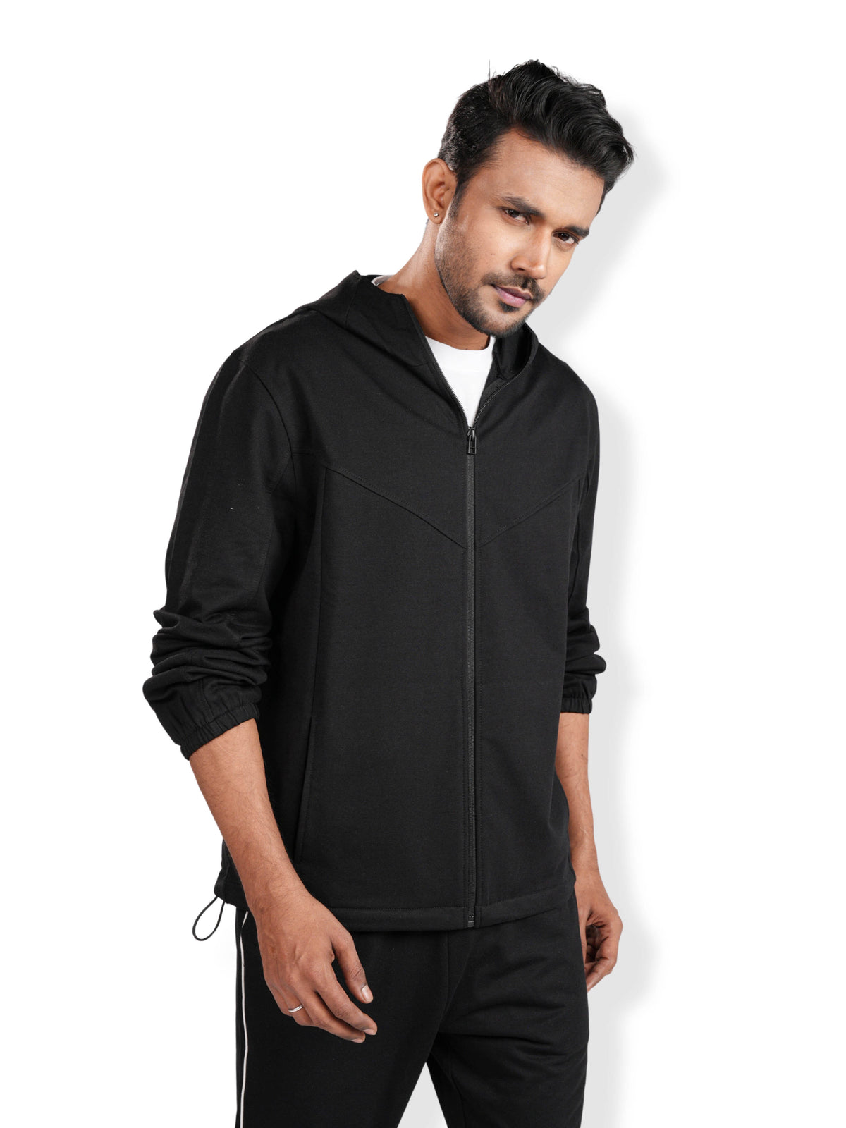 Man wearing a black hoodie and pants on a white background