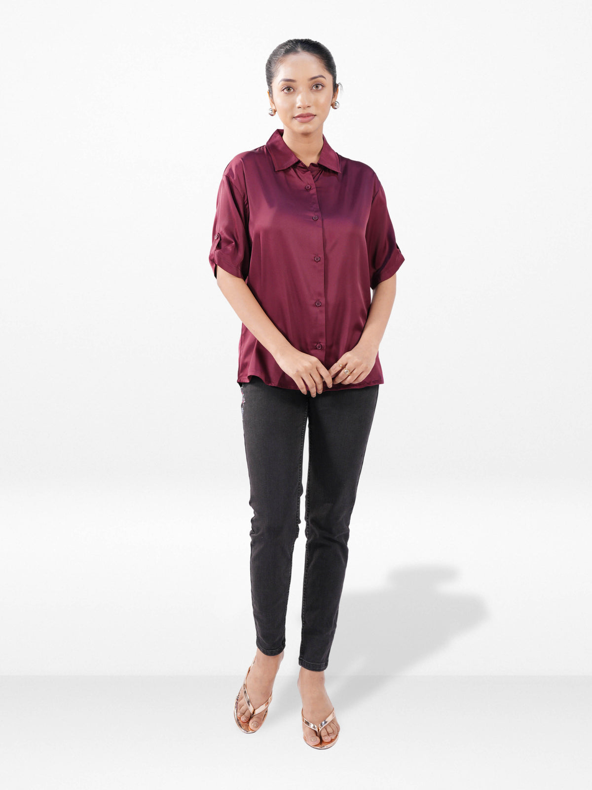 Woman wearing a burgundy shirt and black pants on a white background