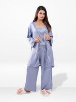 Woman wearing a light blue satin pajama set on a white background