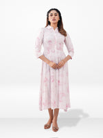 Woman wearing a light pink floral dress on a white background