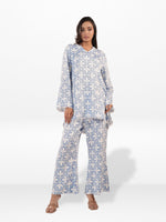 Woman wearing a blue and white patterned outfit on a white background