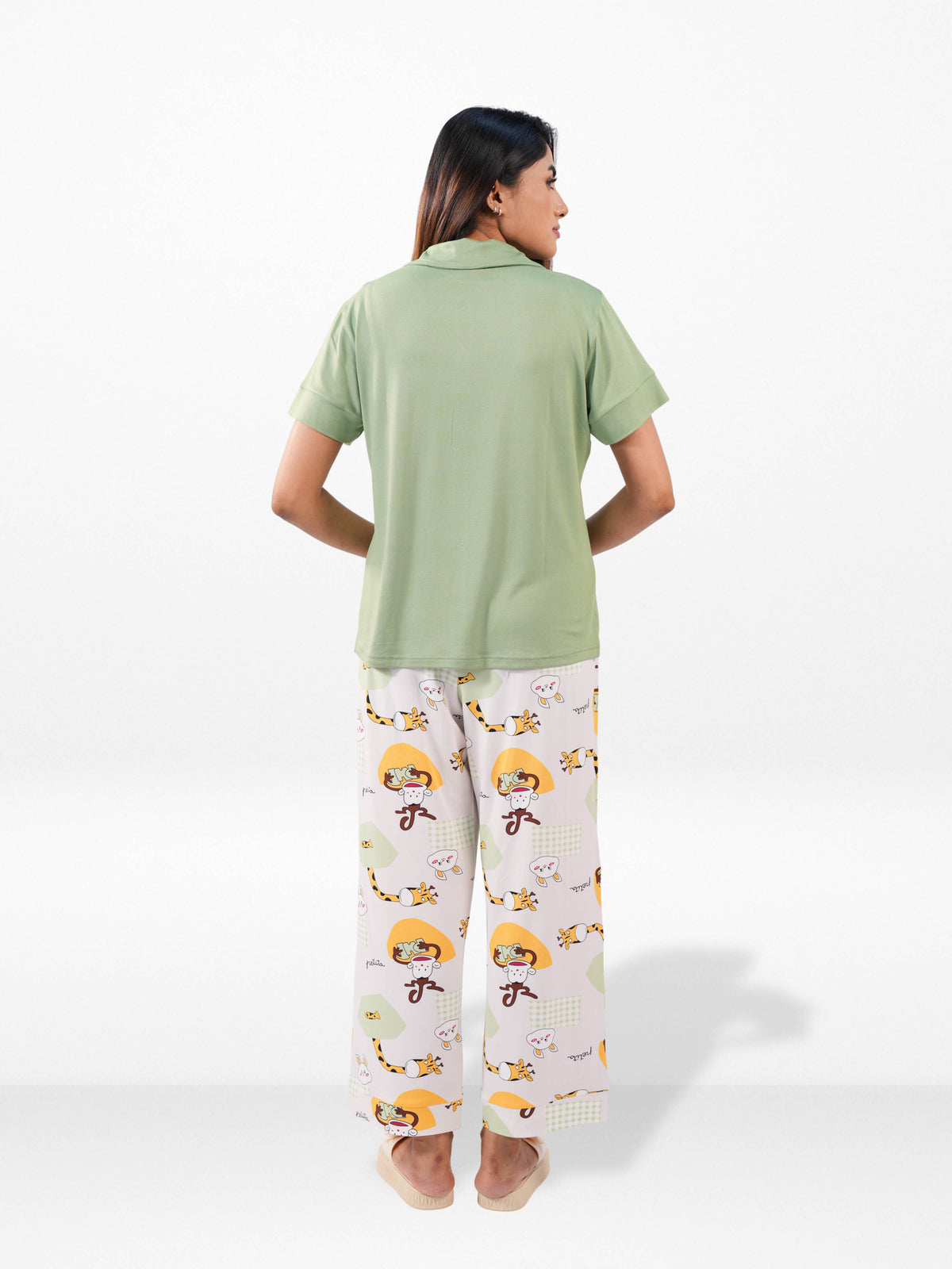 Person wearing a green shirt and patterned pants on a white background
