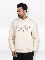 Man wearing a beige hoodie with text on a white background