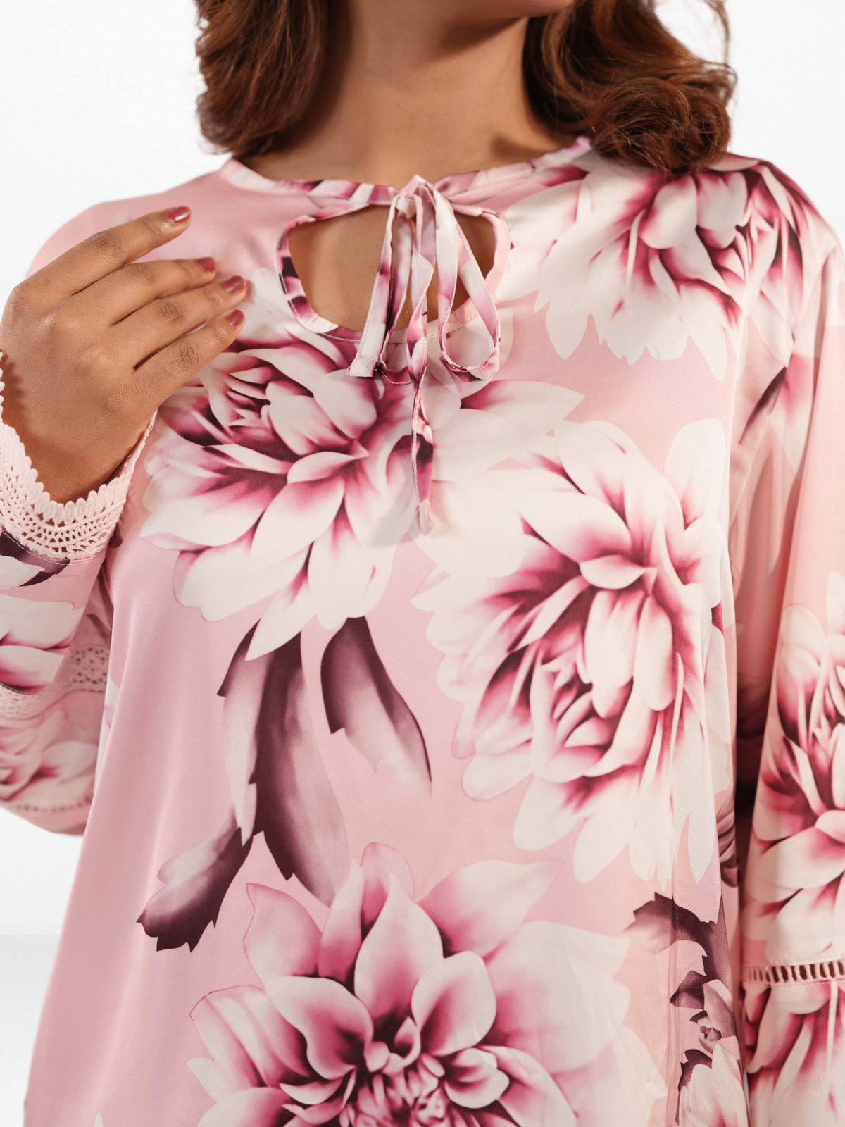 Pink floral dress with lace details on a white background