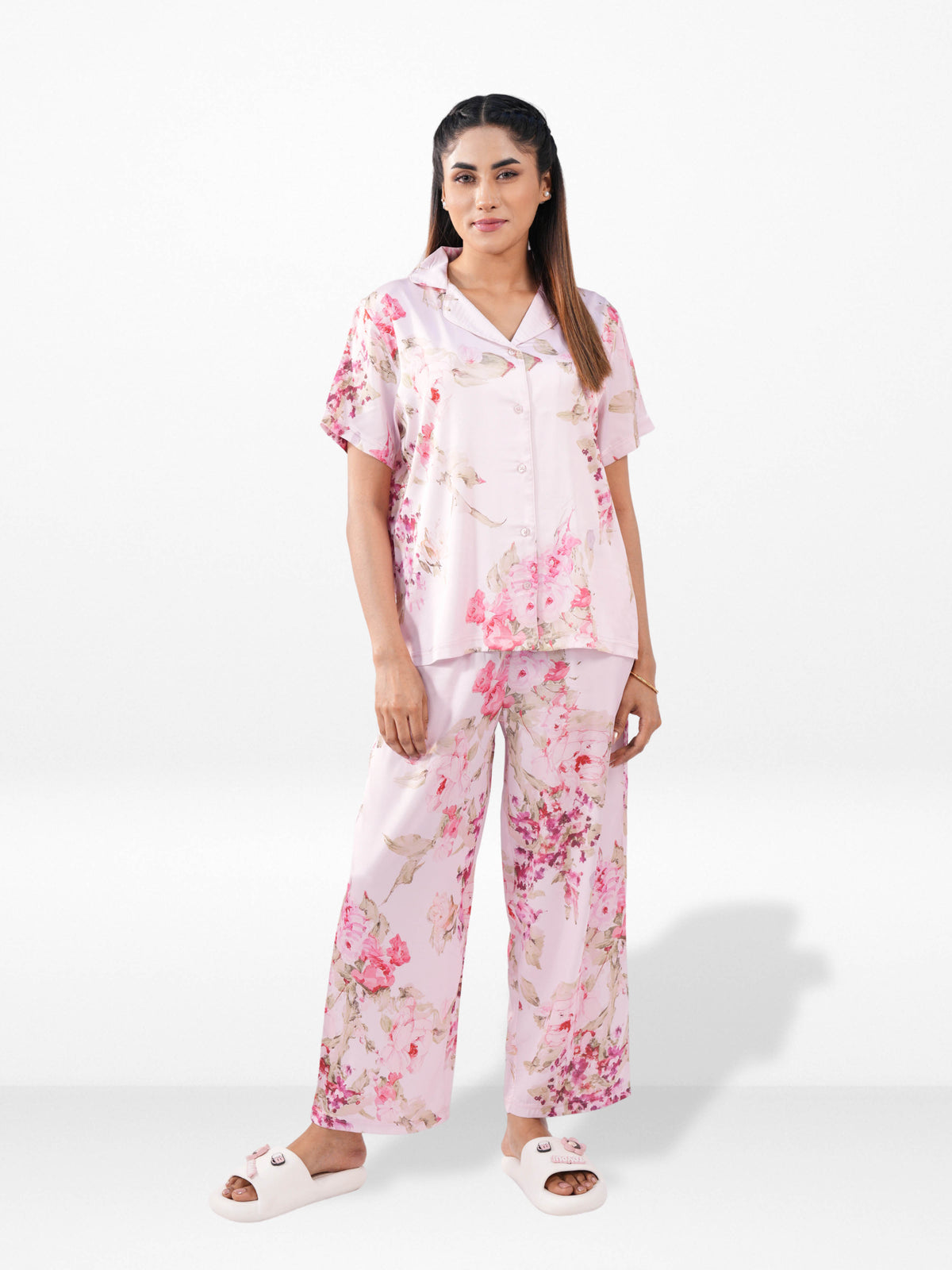 Woman wearing a pink floral pajama set on a white background