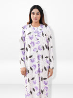 Woman wearing a white nightgown with purple floral pattern on a white background