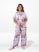 Woman wearing a floral pajama set on a white background