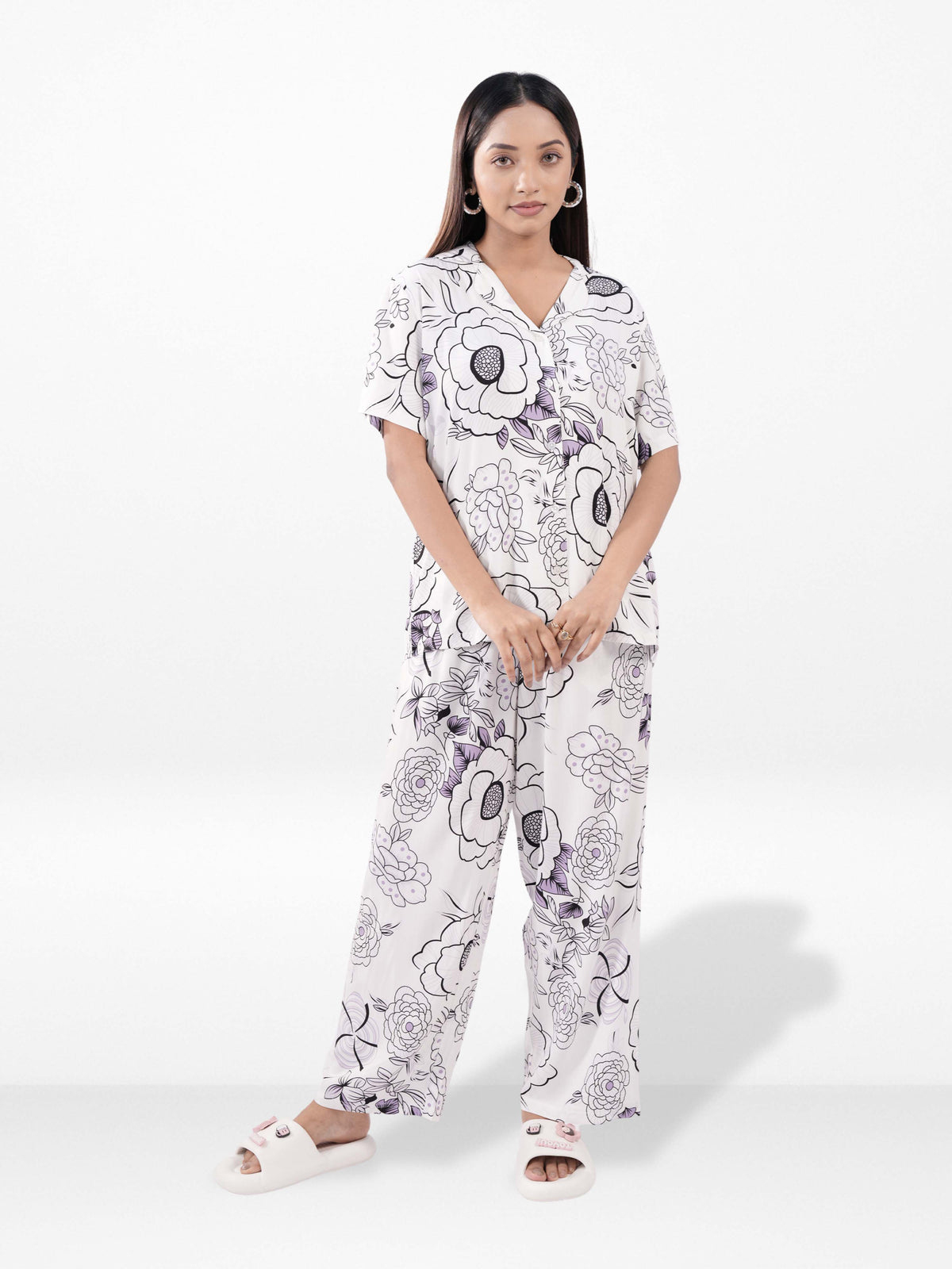 Woman wearing a floral pajama set on a white background