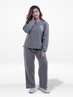 Woman wearing a gray tracksuit on a white background