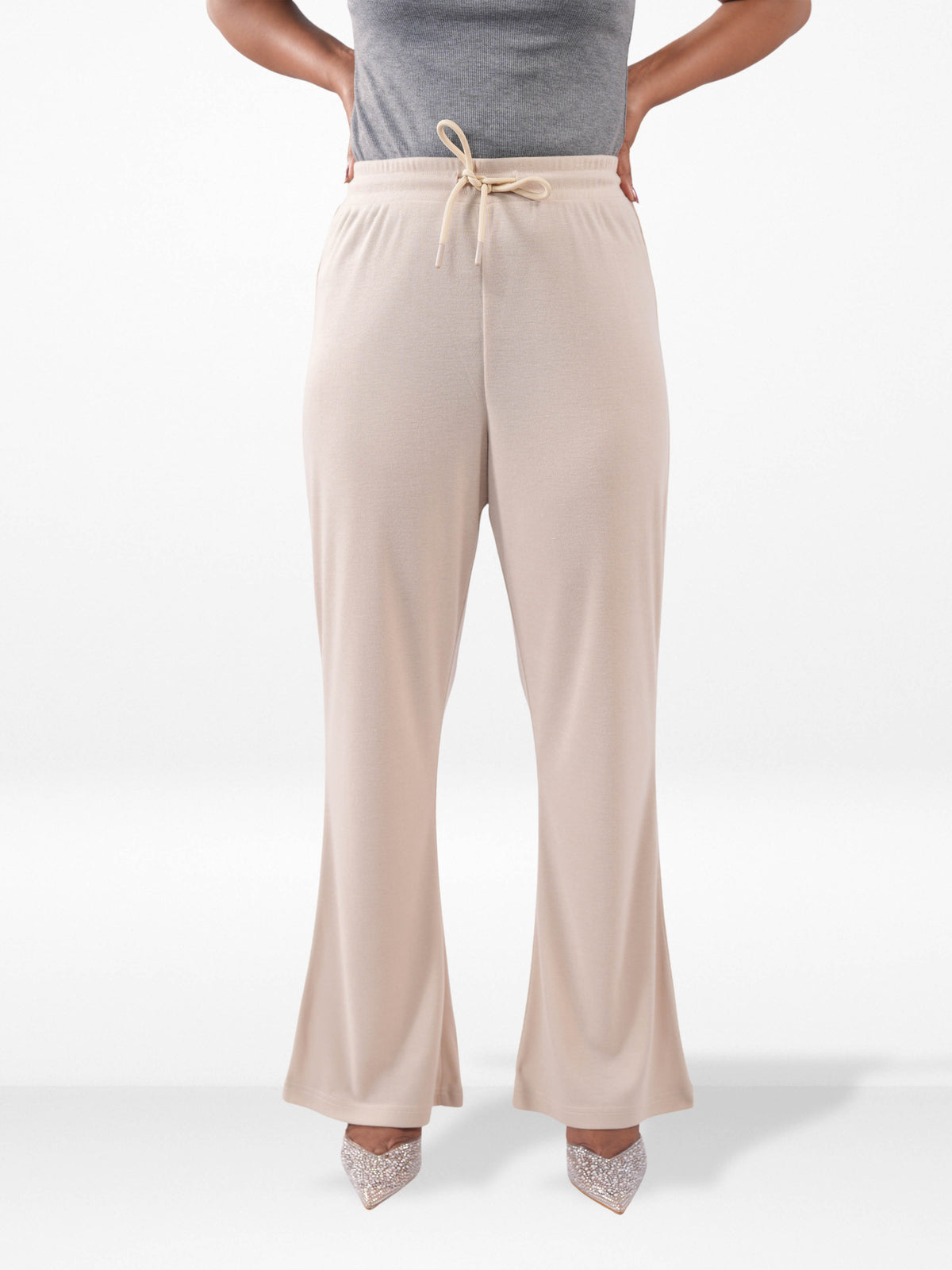 Beige wide-leg pants worn by a person on a white background