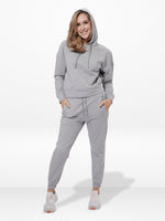 Woman wearing a gray hoodie and jogger set on a white background