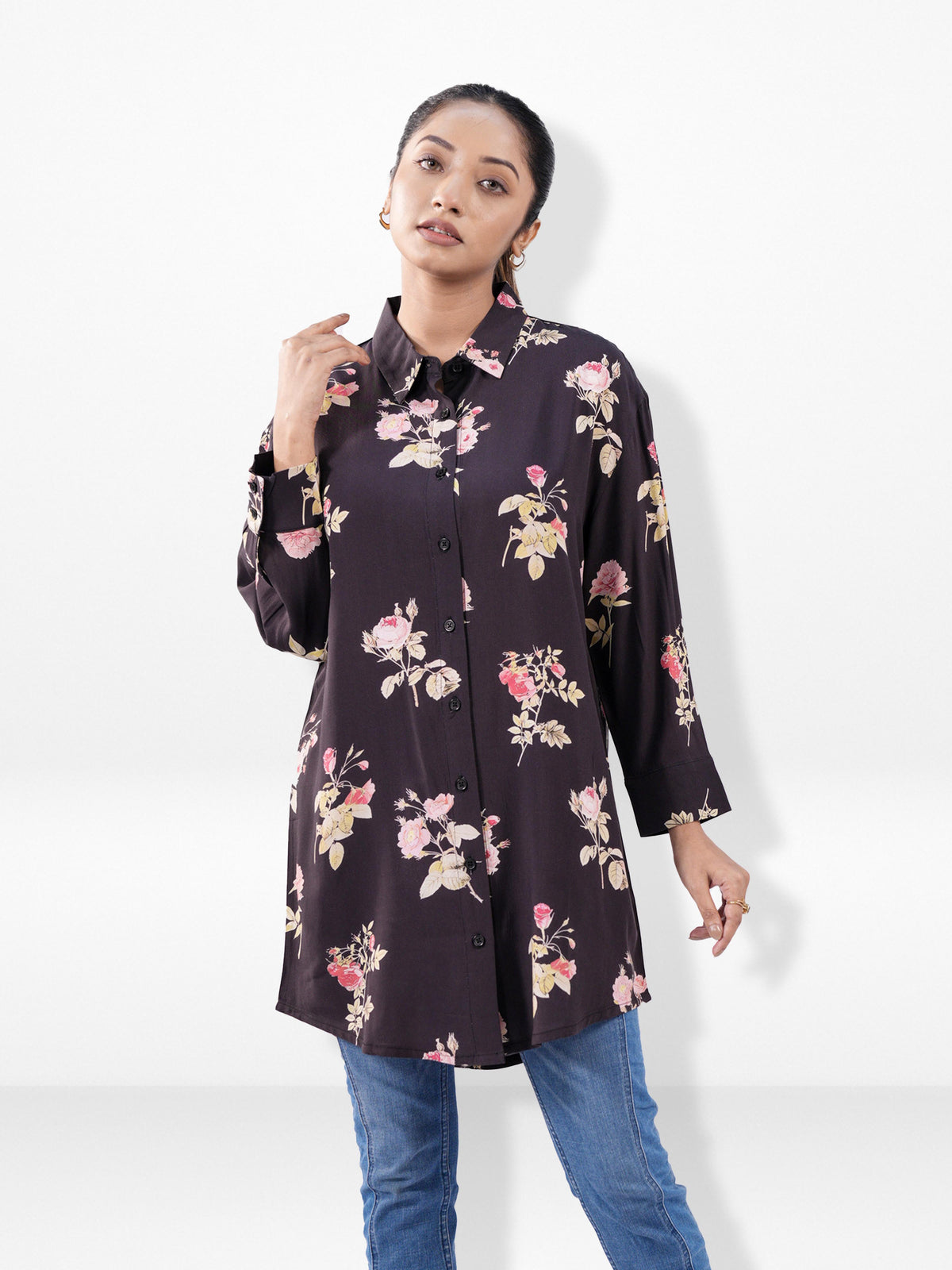 Woman wearing a dark floral shirt against a white background