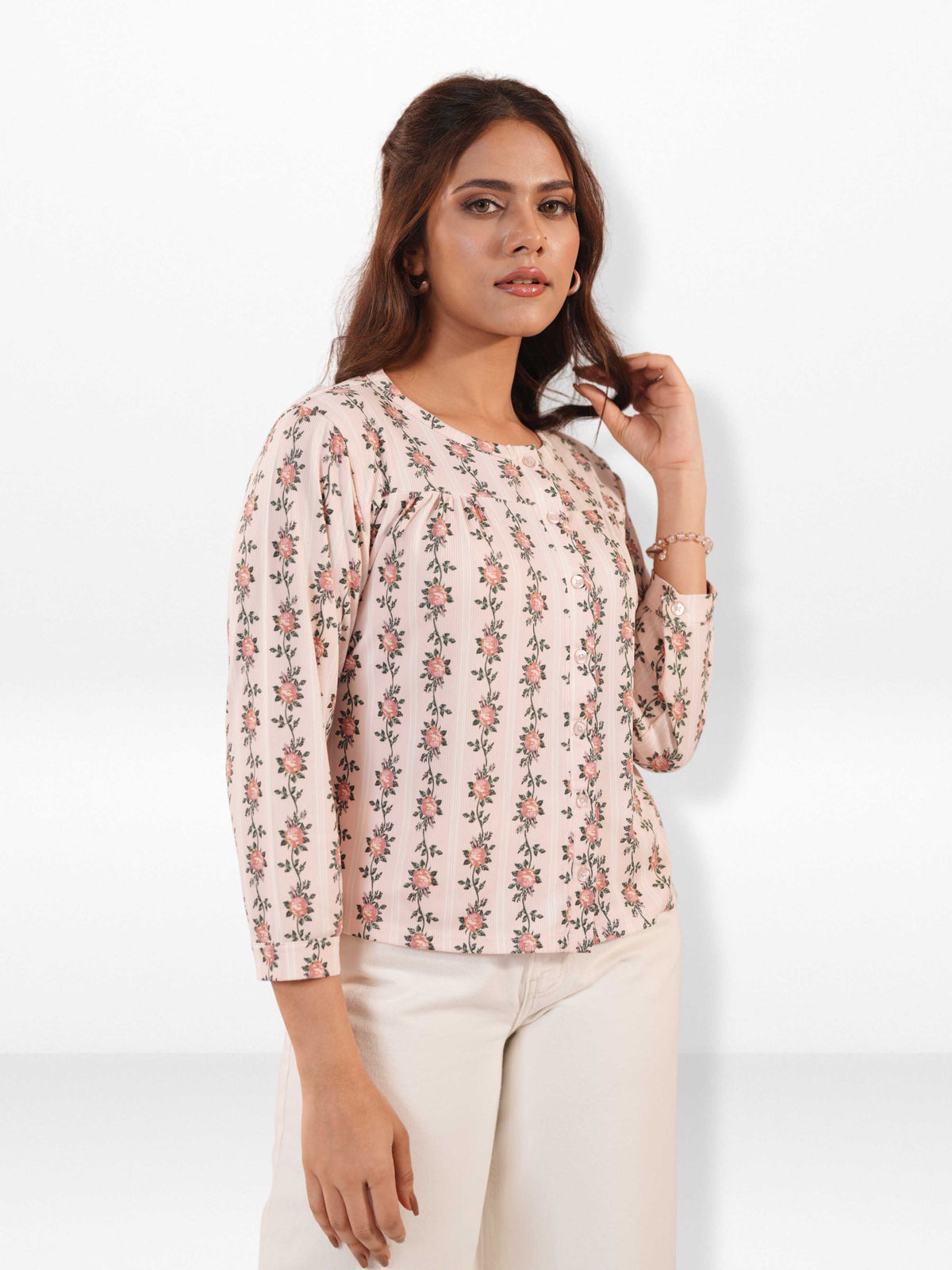 Woman wearing a floral blouse against a white background