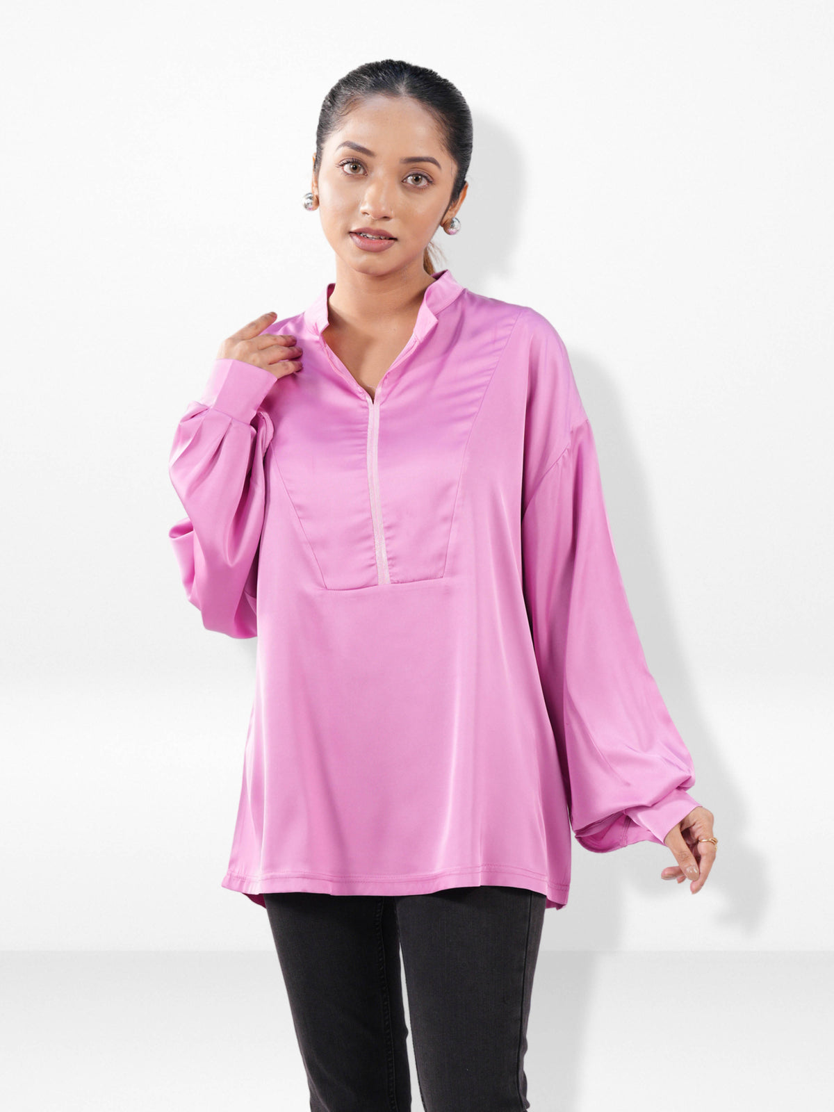 Woman wearing a pink long-sleeve top on a white background