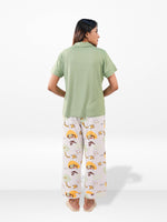 Person wearing a green shirt and patterned pants on a white background